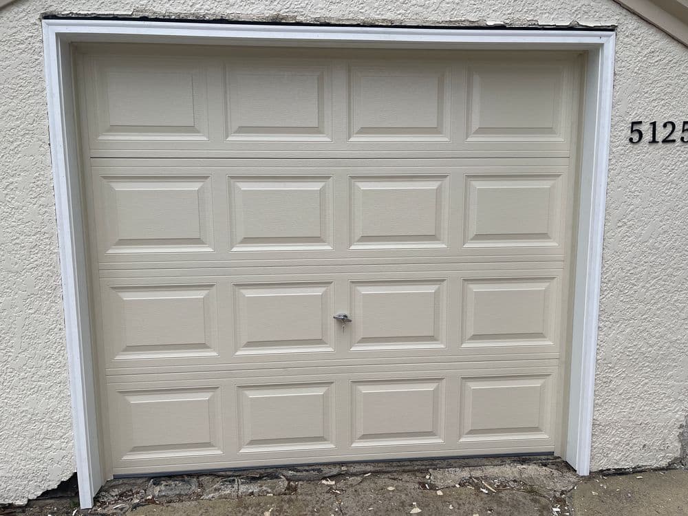 Cream-colored garage door with panel design at residential address 5122.
